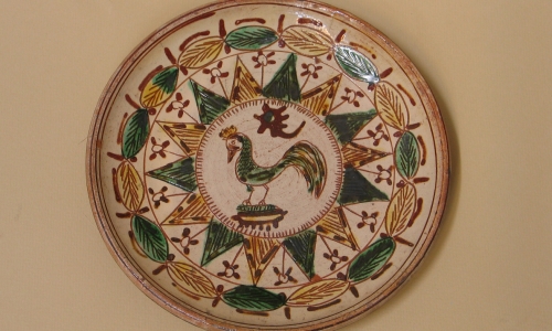 Porcelanowy tależ bogato zdobiony wywodzący się z tzw. ceramiki pokuckiej